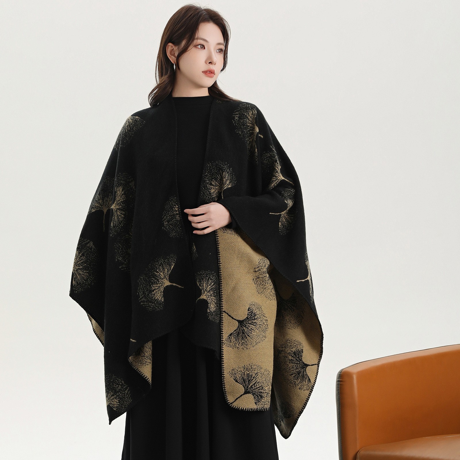 Model wearing a black and gold patterned wrap